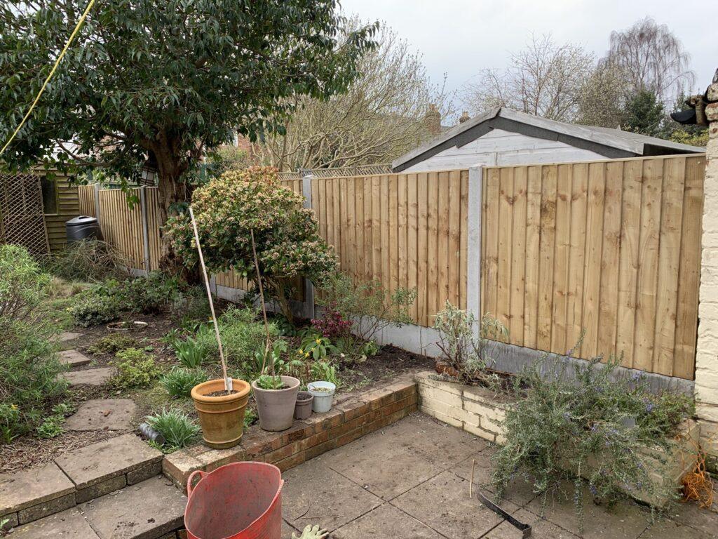 completed panel fence with concrete posts and gravel boards